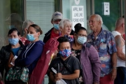 FILE - People line up outside a Kentucky Career Center hoping to find assistance with their unemployment claim in Frankfort, Kentucky, June 18, 2020.