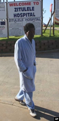 One of the physiotherapist’s patients, who previously could not even sit up in bed, takes a walk through the hospital grounds