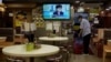 A restaurant employee cleans the floor as a TV screens broadcasting Hong Kong Chief Executive Carrie Lam talks during a press conference in Hong Kong, Friday, July 31, 2020. Hong Kong leader Carrie Lam said Friday that the government will postpone…