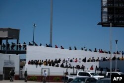 墨西哥最北部的下加州美墨埃尔查帕拉尔过境口岸要求美国当局庇护排队面试的移民队伍。（2024年5月18日）