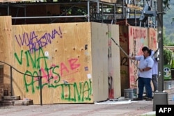 Workers clean up the University of California, Los Angeles (UCLA) campus after police evicted pro-Palestinian students, in Los Angeles, California, early on May 2, 2024.(Photo by Frederic J. Brown / AFP)
