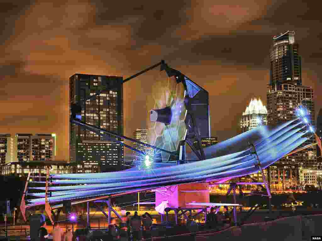 Model teleskop James Webb skala penuh, yang berukuran sebesar lapangan tenis dan setinggi gedung berlantai empat, dipamerkan di kota Austin, negara bagian Texas, Amerika Serikat. Teleskop James Webb milik NASA adalah pengganti teleskop Hubble, dan merupakan teleskop terbesar yang pernah dibuat (Foto; NASA / Chris Gunn).