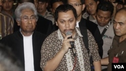 Gayus Tambunan memberikan keterangan kepada media, didampingi pengacaranya, Adnan Buyung Nasution, setelah menjalani sidang di pengadilan Jakarta Pusat, Rabu 19 Januari 2011.