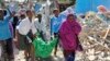 Somalis carry away the body of a civilian who was killed in a car bomb attack in Mogadishu, Somalia, June 20, 2017.