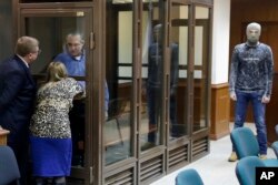 Paul Whelan, a former U.S. Marine, who was arrested in Moscow at the end of last year looks through a cage's glass as he speaks to his lawyers in a court room in Moscow, Russia, Jan. 22, 2019.