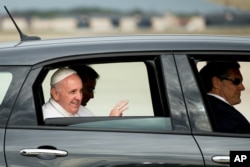 Paus Fransiskus melambai dari Fiat 500L sementara iring-iringan mobil meninggalkan Pangkalah Udara Andrews, Maryland, Selasa, 22 September 2015.