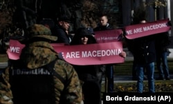 MACEDONIA -- A group of people hold banners reading "We are Macedonia" during anti NATO protest in front of the Parliament in Skopje, Macedonia, while NATO Secretary General Jens Stoltenberg addresses the lawmakers in the Parliament building, Thursday, Ja