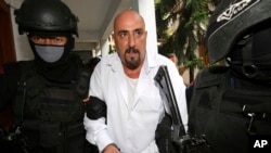 Serge Atlaoui dikawal polisi untuk peninjauan kembali kasus narkoba di Pengadilan Negeri Tangerang, 11 Maret 2015. (Foto: Tatan Syuflana/AP Photo)