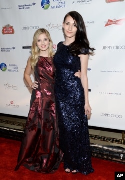 歌手杰基·伊万科（ Jackie Evancho, 左）和她的变性人姐姐朱丽叶·伊万科（Juliet Evancho） 在纽约参加慈善团体全球莱姆联盟主办的晚会（2015年10月8日）