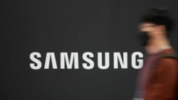 រូបឯកសារ៖ បុរស​ម្នាក់​ដើរ​កាត់​ស្លាកសញ្ញា​ក្រុមហ៊ុន Samsung ក្នុង​ទីក្រុង​សេអ៊ូល ប្រទេស​កូរ៉េខាងត្បូង ថ្ងៃទី២៨ ខែតុលា ឆ្នាំ២០២១។