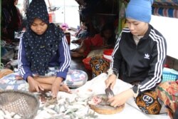 ស្ត្រី​កំពុង​ធ្វើ​ត្រី​ដែលនេសាទ​បាន​ពី​ទន្លេ​មេគង្គ​ ក្នុង​រាជធានី​ភ្នំពេញ នា​រសៀលថ្ងៃ​ទី​២២ ខែ​ឧសភា ឆ្នាំ​២០២១។​ (កាន់ វិច្ឆិកា/វីអូអេ)