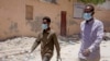 Somali men wear surgical masks on the street after after the government announced the closure of schools and universities and banned large gatherings, Mogadishu, March 18, 2020.