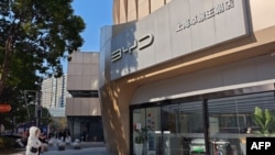 People stand outside an auto shop of the Chinese electric vehicle manufacturer BYD Co. Ltd. in east China's Shanghai on Dec. 27, 2024. A contractor for BYD denied on Dec. 26 there were 'slave-like conditions' in a Brazil factory, 