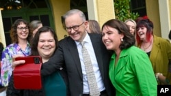 2024年3月8日，澳大利亚总理安东尼·阿尔巴内斯（中）在堪培拉总理官邸举行的国际妇女节早茶会期间与当地妇女支持组织的代表合影留念。