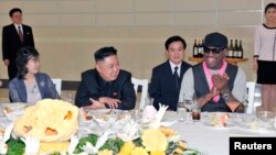 북한의 김정은 국방위원회 제1위원장(가운데)이 지난 2월 방북한 전 미 NBA 농구선수 데니스 로드먼(오른쪽)과 미국 묘기 농구단의 시범 경기를 관람한 후, 만찬을 가지고 있다. 부인 리설주(왼쪽)도 참석했다.