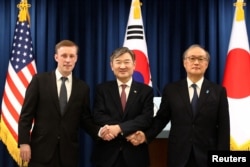 2023年12月9日，韩国国家安全顾问赵泰勇（中），与美国国家安全顾问沙利文（左）以及日本国家安全顾问秋叶武夫（右边）在新闻发布会后握手。（美联社）