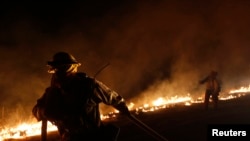 Seorang petugas berusaha memadamkan kobaran api yang melanda kawasan pegunungan Santa Monica, negara bagian California (5/5). 