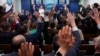 Reporters raise their hands to ask a question in the White House press room, Feb. 20, 2025, in Washington. The AP filed suit against White House officials after being barred from some of President Donald Trump's events. 