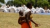 A Zimbabwean mother arrives to collect her monthly rations of food aid from Rutaura Primary School in the Rushinga district of Mt Darwin about 254km north of Harare, March 7, 2013. More than 6 million people across Angola, Lesotho, Malawi and Zimbabwe are at risk of severe food shortages because of repeated cycles of drought and flooding. REUTERS/Philimon Bulawayo 