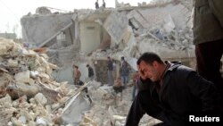 23일 시리아 알레포에서 전날 정부군의 스커드 미사일공격으로 파괴된 지역의 주민들이 망연자실하고 있다.