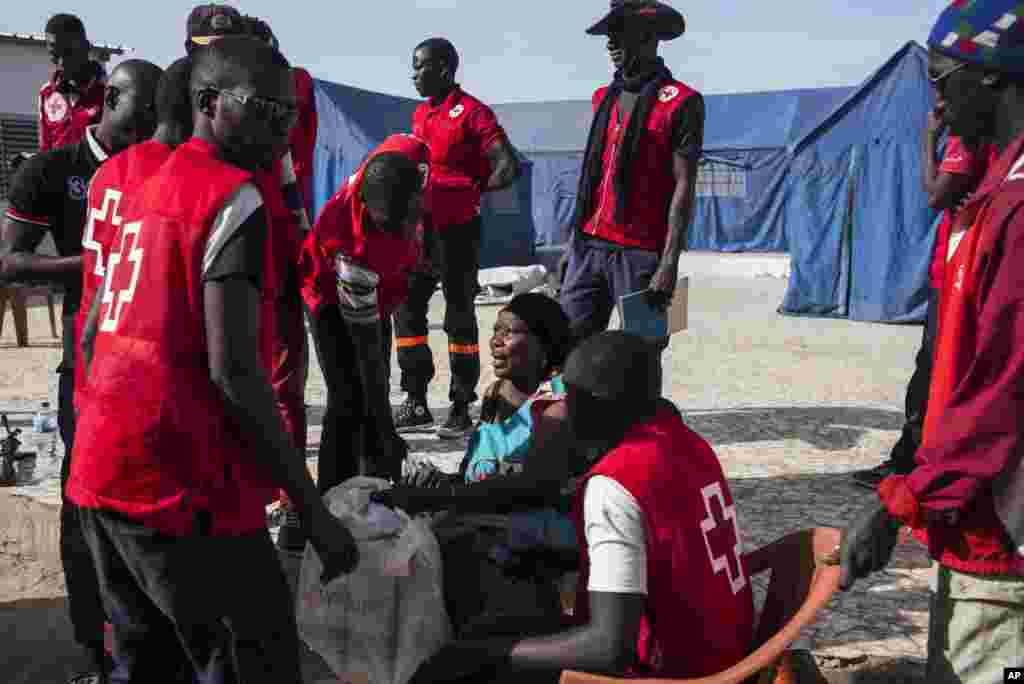 Les éléments de la Croix rouge assistent Fatou Jeng, au centre, après sa traversée à la frontière gambienne avec son enfant, dans le village de Karanga, Sénégal, 19 janvier 2017.