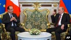 Presiden Perancis Francois Hollande (kiri) berbicang dengan President Rusia Vladimir Putin saat melakukan lawatan di Moskow (28/2). 