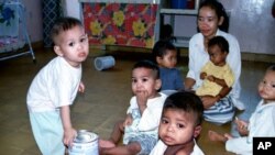 A group of Cambodian orphans gather and play while an orphanage worker looks on (File photo). 