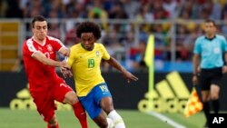 El brasileño Willian, a la derecha, es desafiado por el serbio Filip Kostic durante el partido del grupo E entre Serbia y Brasil, en la Copa Mundial de fútbol 2018 en el Estadio Spartak en Moscú, Rusia, miércoles 27 de junio de 2018. (AP Photo / Rebecca Blackwell)