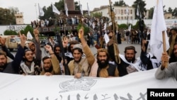 Taliban fighters celebrate the first anniversary of the fall of Kabul