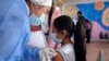A health worker inoculates a child against COVID-19 with a dose of the CoronaVac vaccine, developed by China's Sinovac firm, in Quito on Oct. 18, 2021
