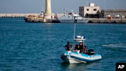 FILE - Italian police patrol a port in southern Italy, April 20, 2018. 