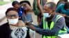 FILE - A woman receives a coronavirus vaccine in Abuja, Nigeria, Nov 29, 2021. 
