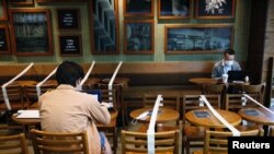 Tables and chairs are taped up to keep social distancing at a Starbucks coffee shop, following the novel coronavirus disease (COVID-19) outbreak, in Hong Kong, China April 2, 2020. REUTERS/Tyrone Siu