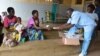 Medical workers distribute nutritious foods to mothers in Zomba district for their children who are at the verge of suffering malnutrition due to the food shortage. (L. Masina/VOA)