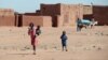 Children walk in the Jaborona settlement for displaced people from South Kordofan and South Sudan in the desert near Khartoum's twin city Omdurman, December 23, 2012.