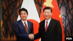 2017年11月11日习近平在越南与安倍会谈前笑容握手（日本首相官邸档案图片）