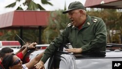 Venezuela's President Hugo Chavez greets supporters as he passes through the town of La Fria, on his way to La Grita, Venezuela, October 20, 2011.