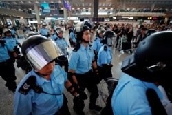 Riot police walk inside the airport as anti-extradition bill protesters gather outside, in Hong Kong, China September 1, 2019. REUTERS/Tyrone Siu