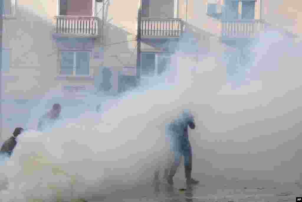 그리스의 신종 코로나바이러스 방역 지침을 어기고 거리로 나온 수백명의 공산당(KKE) 산하조직 전노동자투쟁전선(PAME) 시위대가 진압경찰이 발사한 최루탄 가스를 피하고 있다. 시위대는 1973년 군사독재에 항거했던 대학생 봉기 48주년을 맞아 아테네에서 대규모 시위를 벌였다.