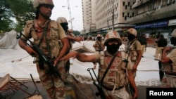 Paramilitary soldiers stand guard near the dismantled makeshift tents of the supporters of Muttahida Qaumi Movement (MQM) political party after a protest, in Karachi, Pakistan, Aug. 22, 2016.