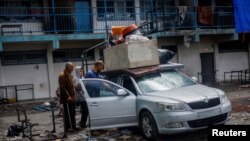 Palestinezë të zhvendosur, që po strehoheshin në një shkollë, përgatiten ta braktisin Rafahun më 13 maj, 2024/Reuters