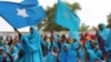 Somali women wave their national flag at Konis stadium, in Mogadishu, during a ceremony marking the anniversary of Somalia’s independence, July 1, 2012. 