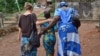 Cora, a trafficking survivor, walks with her case manager and social worker in Sierra Leone. Credit: WHI