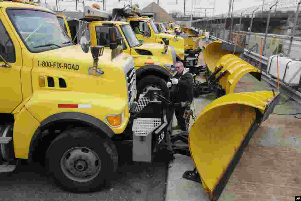 Seorang pekerja Departemen Perhubungan menyiapkan mobil-mobil pembersih salju untuk menghadapi badai musim dingin, Kamis (2/1). (AP/Matt Rourke)