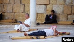 Des Musulmans lisent le Coran à l'intérieur de la mosquée Zitouna pendant le ramadan à Tunis, en Tunisie, le 15 juin 2016.