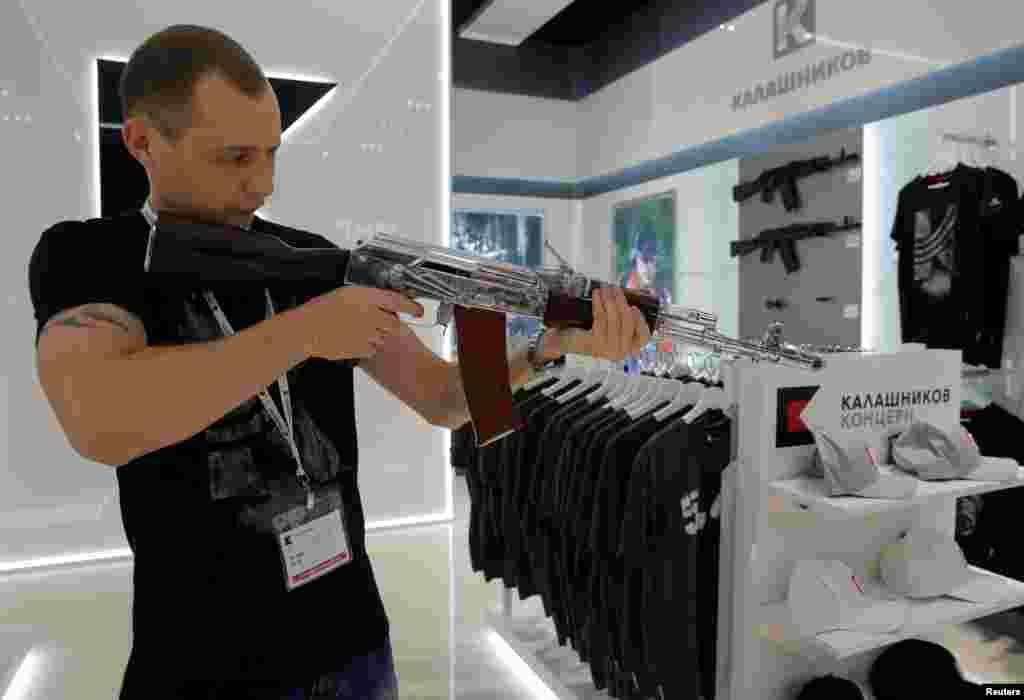 Seorang penjual mendemonstrasikan &quot;model&quot; senjata AK-47 pada toko souvenir senjata Kalashnikov di bandara Sheremetyevo, Rusia.