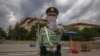 FILE - A Chinese People's Liberation Army soldier gestures to the photographer to stop taking photos in front of the Great Hall of the People, after the second plenary session of China's National People's Congress, in Beijing, May 25, 2020.