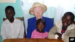 Mary Owido, albinos, assise avec ses enfants, Steven, à gauche, Stella, and Brayan.