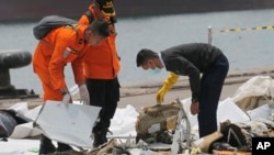Seorang penyelidik memeriksa bagian-bagian Penerbangan Lion Air 610 yang diambil dari perairan Tanjung Priok di Jakarta, Indonesia, Rabu, 31 Oktober 2018. (Foto: AP/Tatan Syuflana)