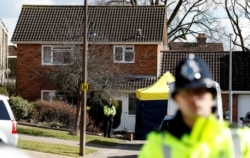 FILE - Police officers stand guard outside the home of Sergei Skripal in Salisbury, Britain, March 8, 2018.